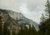 Národní park Yellowstone: co vidět a itinerář Skupiny návštěvníků na parkovišti u Yellowstonu s foťáky a průvodci, v pozadí kouří gejzír