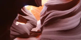 Antelope Canyon a Horseshoe Bend: kompletní průvodce Návštěvníci procházejí úzkým slot canyonem se stěnami vysoko nad hlavami, v poledním slunci